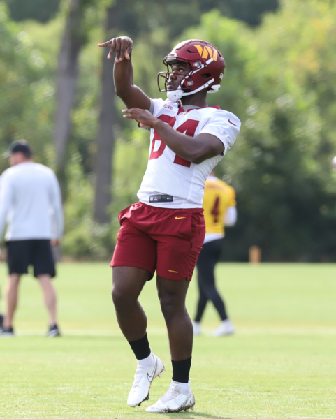 WR Jequez Ezzard (84) tossing the ball with a coach before pract