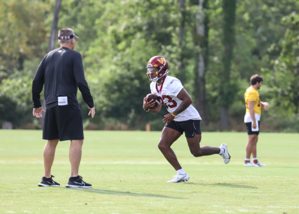 WR Kyric McGowan (83) running around a coach during the Commande