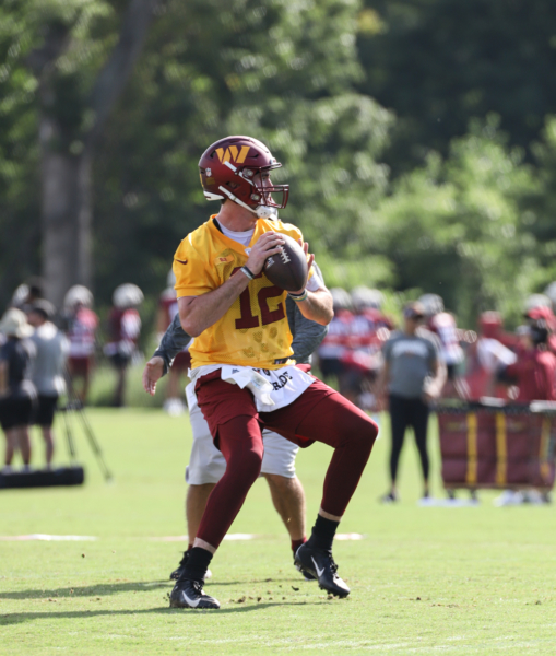 Quarterback Cole Kelley (12) prepares to make a throw at the Com