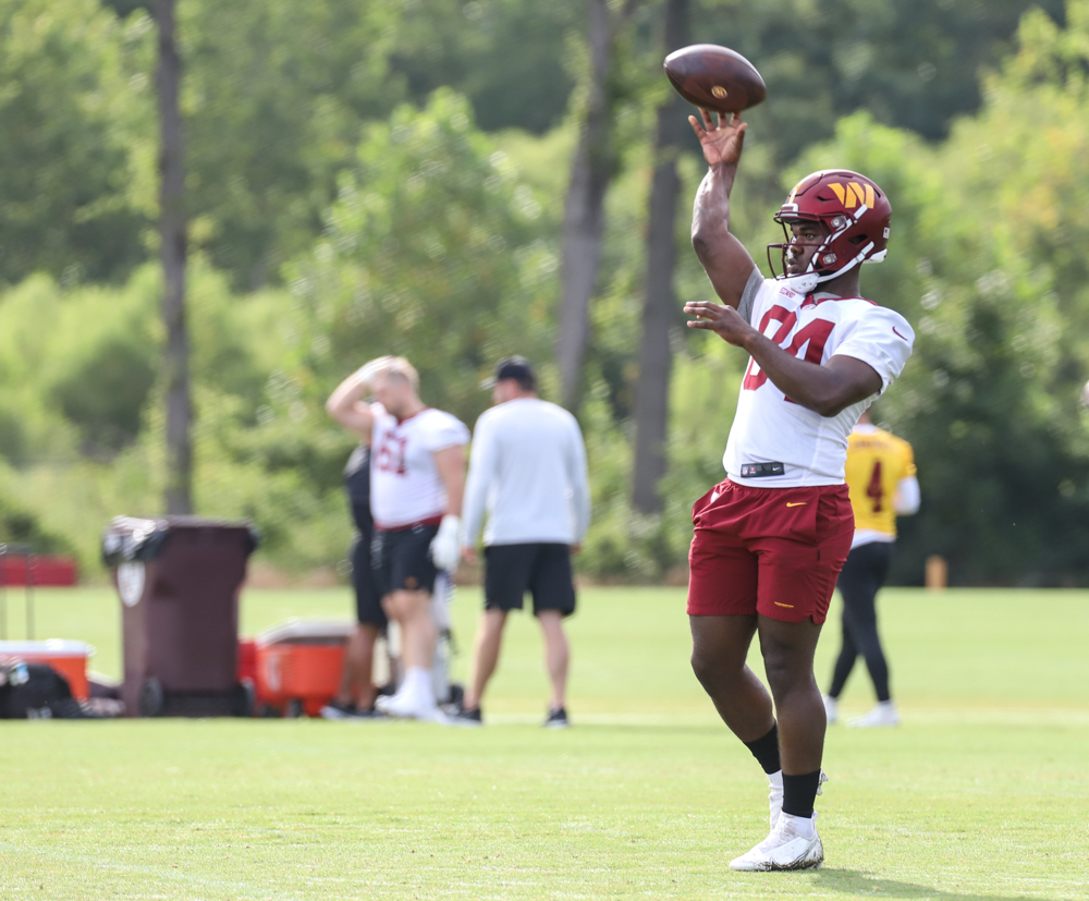 WR Jequez Ezzard (84) tossing the ball with a coach before pract